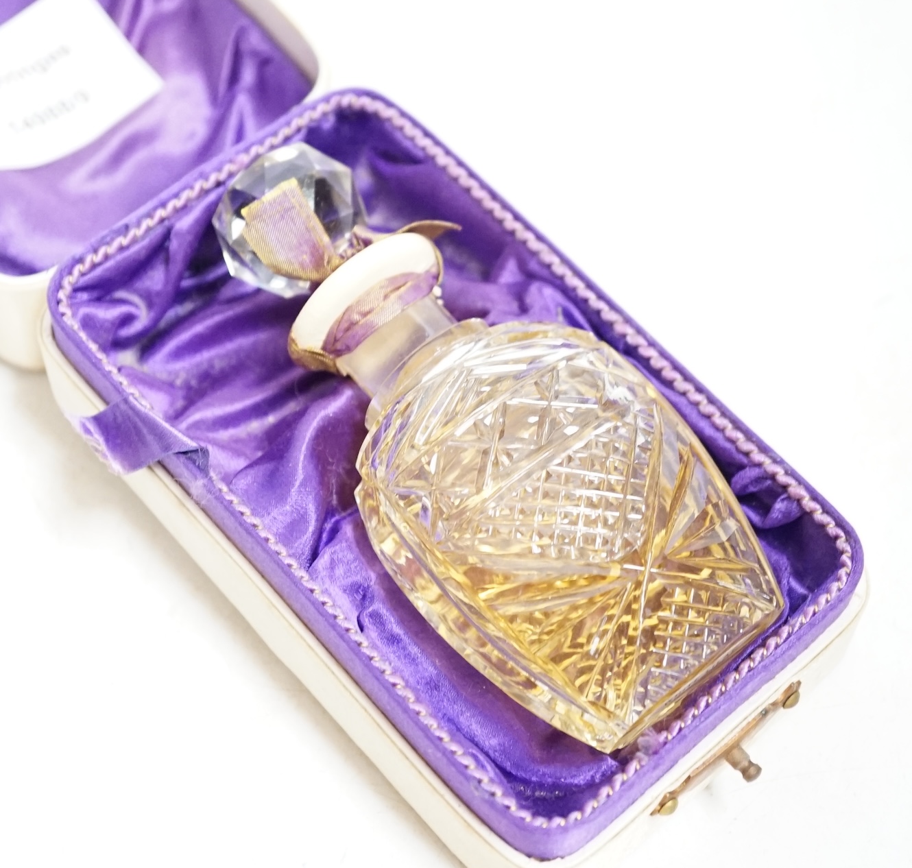 An early 20th century Vinolia cut glass scent bottle and stopper labelled White Lilac, with original case. Condition - fair